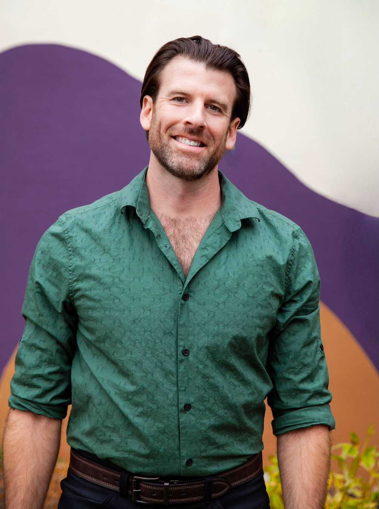 Dr. Jason Rogers smiling in a blue shirt, photographed indoors in natural light